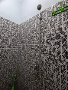 uma casa de banho com um chuveiro com uma parede estampada em OYO 93340 Angsana Aglow Homestay em Duri