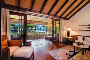 a living room with a couch and a table at The Oberoi Beach Resort, Lombok in Tanjung
