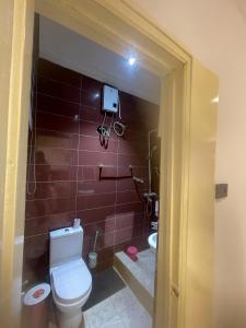 łazienka z toaletą i kamerą na ścianie w obiekcie Rich homes w mieście Baatsona