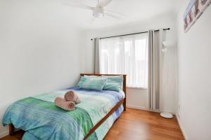 een slaapkamer met een bed met twee hoeden erop bij Villa Zelma I Pet Friendly I 4 Min Walk to Beach in Culburra Beach