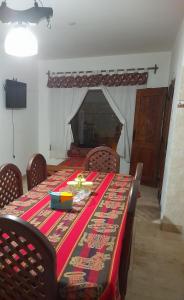 a dining room with a table with a red table cloth at Hospedaje Lupé in Cachí