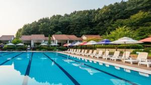 a swimming pool with chairs and umbrellas at Damyang Spa and Tourist Hotel in Damyang