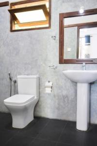 a bathroom with a toilet and a sink at Daasa Guest Mirissa in Mirissa
