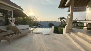 een huis met een zwembad en een patio bij Villa Michiko in Uluwatu