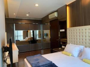 a bedroom with a large bed with a large mirror at 2br- Central Park Residence Alaina Tower Floor 29 in Jakarta
