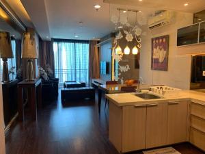a kitchen with a sink and a living room at 2br- Central Park Residence Alaina Tower Floor 29 in Jakarta