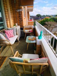 a balcony with wicker chairs and a table at Sunny 2 bed Restaurants beach at door Pets O.K in Sydney