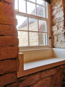 une fenêtre avec un banc blanc dans un mur de briques dans l'établissement Lincoln Country House for Groups with Hottub, à Lincoln