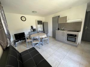 a kitchen and living room with a table and chairs at Les maisonnettes de bonneval in Jaujac