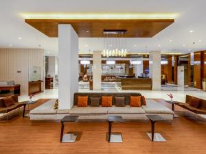 a living room with a large couch in the middle at Flora Al Barsha Hotel At The Mall in Dubai