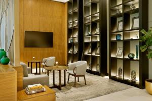 a living room with a tv and a table and chairs at Sheraton Astana Hotel in Astana