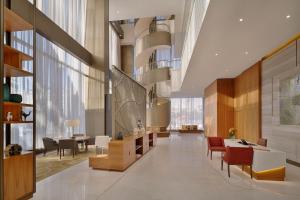 a lobby with chairs and tables and windows at Sheraton Astana Hotel in Astana