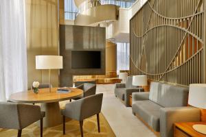 a lobby with a table and chairs and a television at Sheraton Astana Hotel in Astana