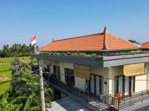a house with a balcony with plants on it at KRISNA TAPAN GUEST HOUSE in Ubud