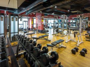 a gym with several rows of weight machines at Flora Inn Hotel Dubai Airport in Dubai