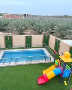 a pool with a slide and a playground at Traveler Rooms 2 in Al Madinah