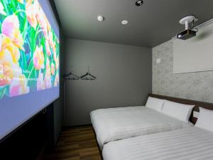 a room with two beds and a projection screen at Rakuten STAY Nikko Hoden No pets allowed Capacity of 6 persons in Nikko