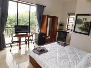 a bedroom with a bed and a desk and a table at Tom's Place in Siem Reap