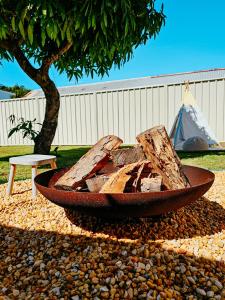 a wooden bowl sitting on a pile of rocks next to a tree at 2 Min Walk to Beach Firepit Yard Kids welcome in Ettalong Beach