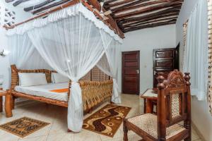 una camera con letto e zanzariera di Diani Beach-Villa Kirsch a Galu