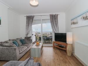 a living room with a couch and a tv at 2 Moorlands in Minehead