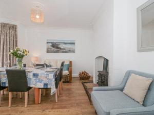 a living room with a dining room table and chairs at 2 Moorlands in Minehead