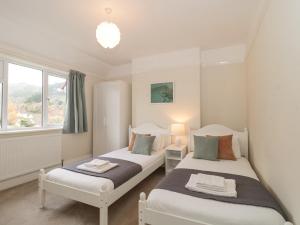 two twin beds in a room with a window at 2 Moorlands in Minehead