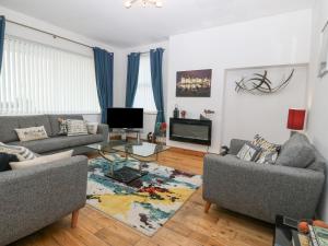 een woonkamer met 2 banken en een televisie bij Coed Llai in Holyhead