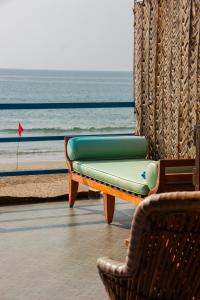 un divano e una sedia di fronte alla spiaggia di New Common Home ad Agonda