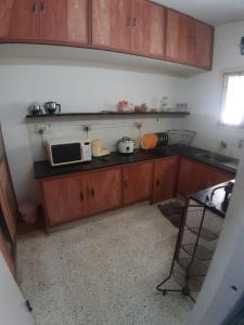 a kitchen with wooden cabinets and a microwave at GG Homes - Apollo/Shankara Hospital in Chennai