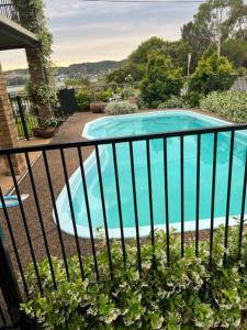 a swimming pool in a yard with a fence at By the Lake - Lake Macquarie in Teralba