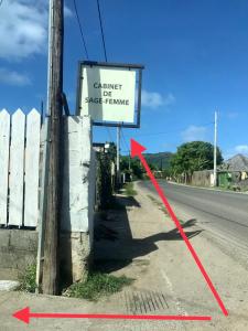 a sign with a red arrow next to a road at Mianahere Studio Bora Bora in Bora Bora