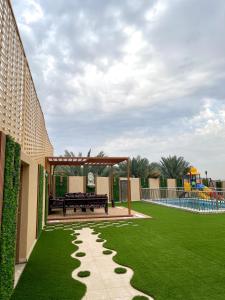 a garden with a bench and a playground at Traveler Rooms 2 in Al Madinah