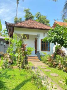 a small white house with a pathway in front of it at suris bungalow 2 in Pabean Buleleng