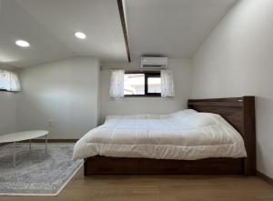 Un dormitorio con una cama grande y una ventana en An Gimnyeong Stay, en Jeju