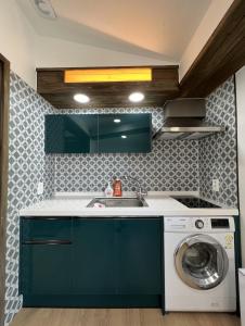 a kitchen with a washing machine and a sink at An Gimnyeong Stay in Jeju