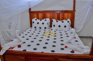 a bed with black and white sheets and pillows at Nyota Apartment in Nungwi