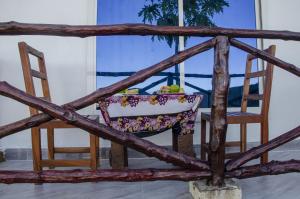une chaise en bois et une table avec un bol de fruits dans l'établissement Nyota Apartment, à Nungwi