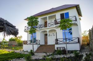 une maison blanche avec un escalier en face de celle-ci dans l'établissement Nyota Apartment, à Nungwi