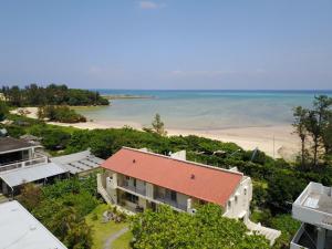 una vista aérea de una casa y de la playa en Arimabaru Beach Resort, en Motobu