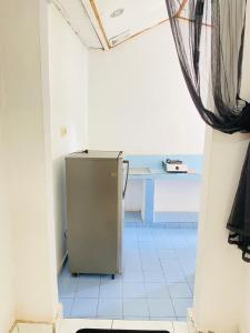 a small refrigerator in a room with a table at suris bungalow 2 in Pabean Buleleng