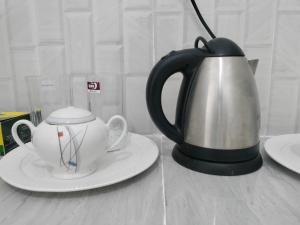 a tea kettle and a cup on a table at Nyota Apartment in Nungwi