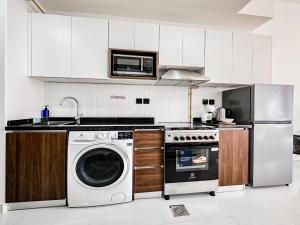 a kitchen with a washing machine and a microwave at Perfect Studio in Arjan in Dubai