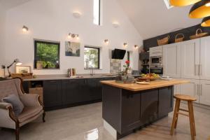 a kitchen with black and white cabinets and a counter at Beautiful Luxury one bedroom retreat in Far Sawrey in Far Sawrey +22 photos