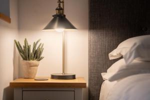 a lamp on a night stand next to a bed at Beautiful Luxury one bedroom retreat in Far Sawrey in Far Sawrey