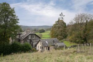 an old house on the side of a hill at Beautiful Luxury one bedroom retreat in Far Sawrey in Far Sawrey