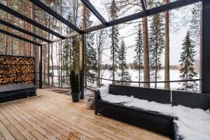 un porche cubierto de nieve con vistas a un bosque cubierto de nieve en Ternu Minivilla en Rovaniemi