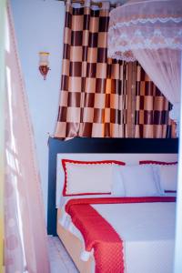 - une chambre avec un lit doté d'un rideau rouge et blanc dans l'établissement SILVER HOTEL APARTMENT Near Kigali Convention Center 10 minutes, à Kigali