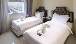 Dibba Sea View Hotel by AMA Pro في دبا: غرفه فندقيه سريرين وعليها فيل