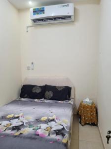 a bedroom with a bed with flowers on it at Budget Hostel Rooms in Al Ain